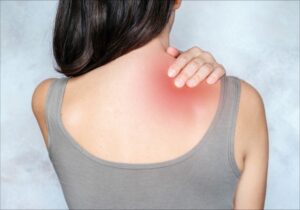 woman massaging painful trigger point on shoulder to relieve pain
